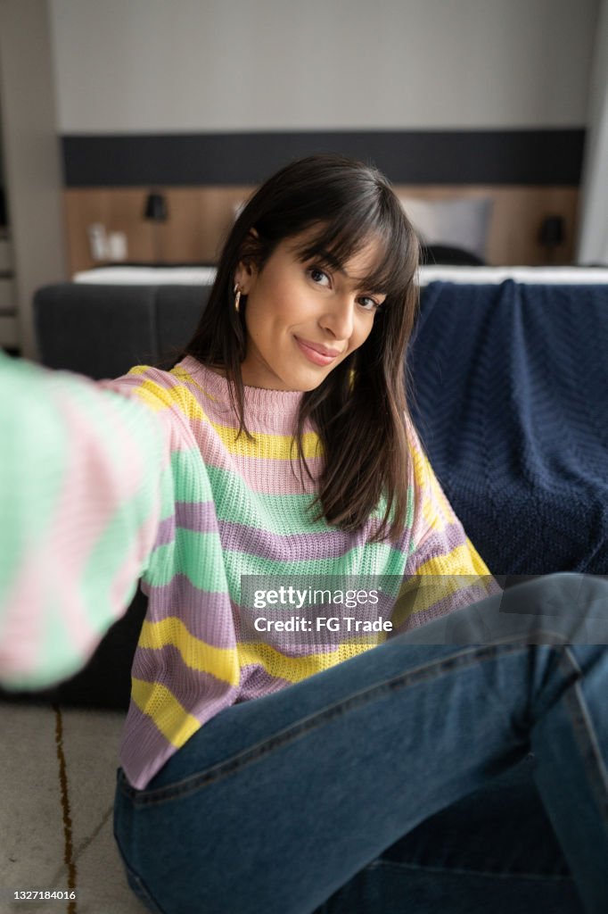 Young woman taking a selfie at home - camera point of view