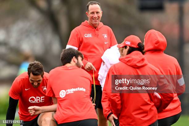 Don Pyke the assistant coach of the Swans has a laugh with his players during a Sydney Swans AFL training session at Xavier College on July 06, 2021...