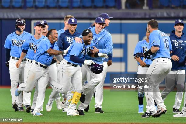 Yandy Diaz of the Tampa Bay Rays celebrates with teammates after an RBI walk-off grounder against the Cleveland Indians at Tropicana Field on July...