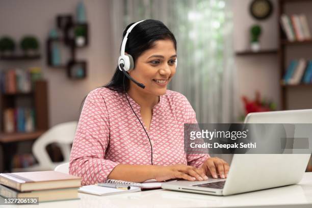 happy business women and teacher with headphones using laptop for video call:- stock photo - india train stock pictures, royalty-free photos & images