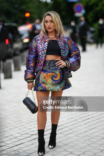 Florence Pugh wears a gold large chain necklace from Louis Vuitton, a black crop-top / t-shirt, a blue shiny with pink fuchsia and black leopard...