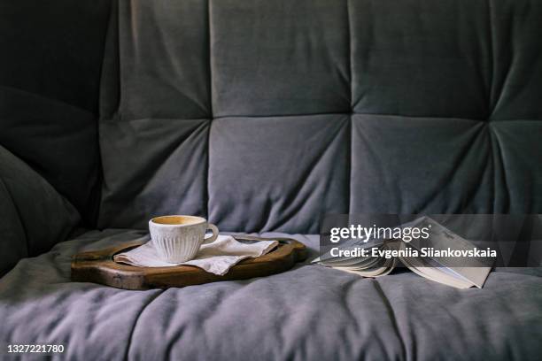 composition of cup of coffee and opened book on the sofa in the room. - romance book covers stock-fotos und bilder