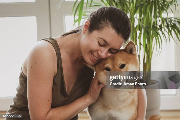 woman training at home, watching online videos on laptop, shiba inu dog sleeping near her - shiba inu adult stock pictures, royalty-free photos & images