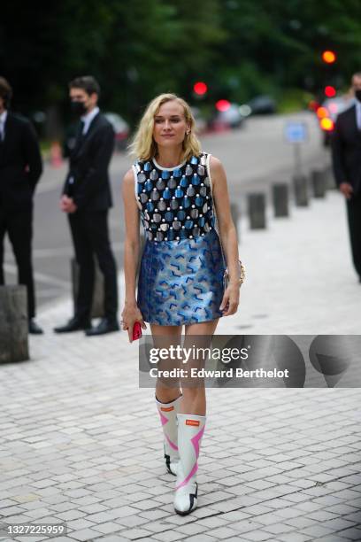 Diane Kruger wears gold and pearls earrings, a black tank top with shiny silver sequins and white pearls embroidered, a silver and blue shiny leather...