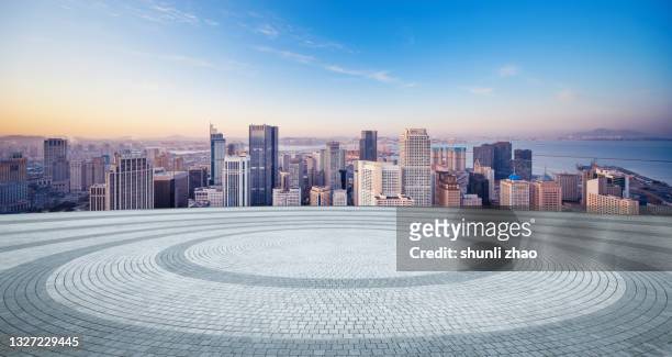 a circular square with the city skyline as the background - circular business district stock-fotos und bilder