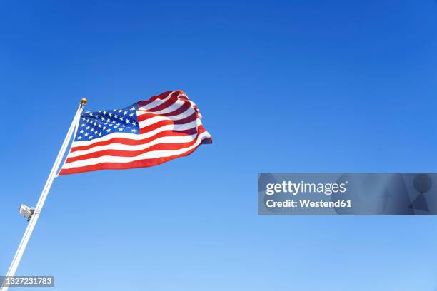 american flag waving during sunny day - us flagge stock-fotos und bilder