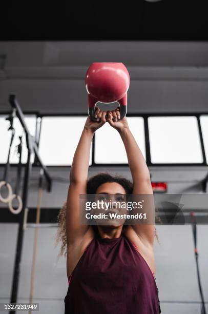 sportswoman exercising with kettlebell at health club - kettle bells fotografías e imágenes de stock