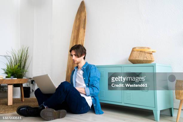 male entrepreneur using laptop while working at creative workplace - person surfing the internet stock pictures, royalty-free photos & images