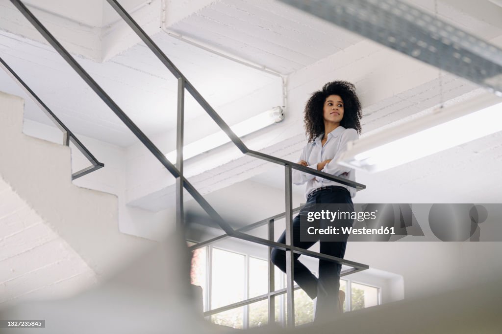 Arm On Railing Female Professional With Arms Crossed Contemplating While Leaning On ...
