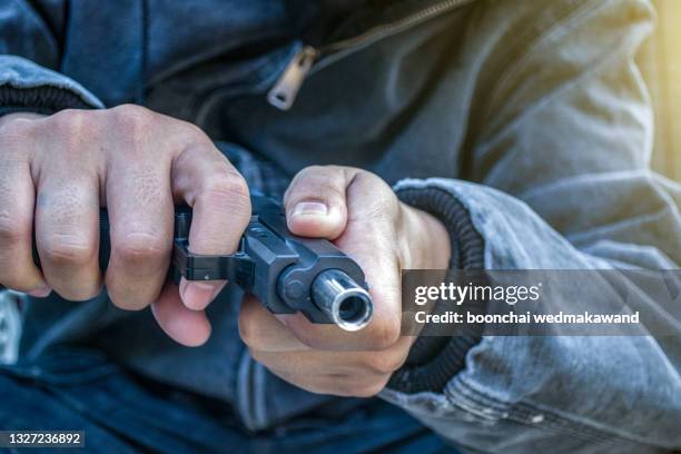 young man took aim with pistol near village roads. - pistool handwapen stockfoto's en -beelden