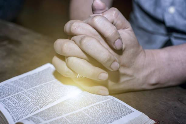 human hand placed on the bible, pray to god. - gospel - fotografias e filmes do acervo