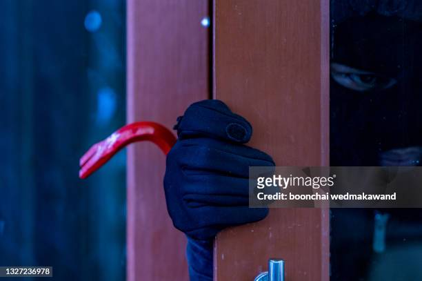 burglar with crowbar - vandalismus haus stock-fotos und bilder