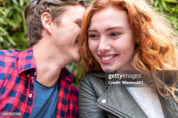 man whispering girlfriend at pub - woman whisper to man stock pictures, royalty-free photos & images