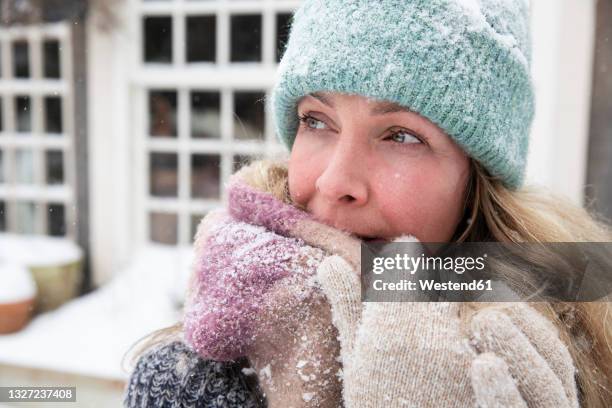 blond woman covering mouth with scarf while looking away - holland achtertuin stockfoto's en -beelden