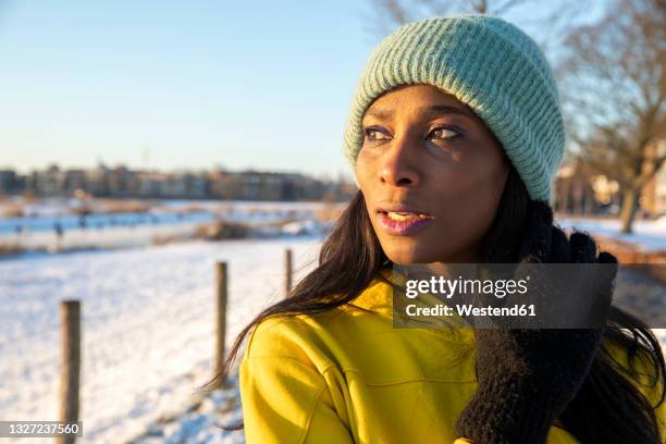 beautiful mature woman wearing blue knit hat while looking away - yellow glove stock pictures, royalty-free photos & images