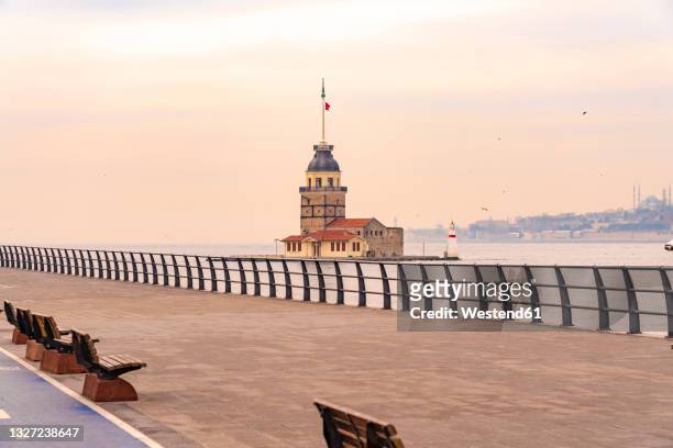 turkey, istanbul, empty uskudar promenade at dusk with maidens tower in background - bosphorus stock pictures, royalty-free photos & images
