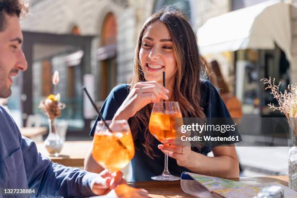 smiling woman with drink looking at man during sunny day - florence stock pictures, royalty-free photos & images