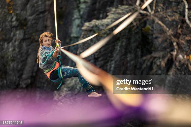 young woman highlining in mountains at baden-baden, germany - riesgo fotografías e imágenes de stock