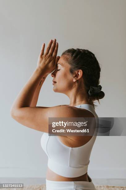 fitness instructor with hands clasped practicing yoga at health club - health club 個照片及圖片檔