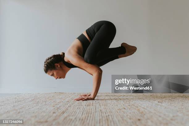 yogi practicing kakasana pose in health club - fare la verticale sulle mani foto e immagini stock