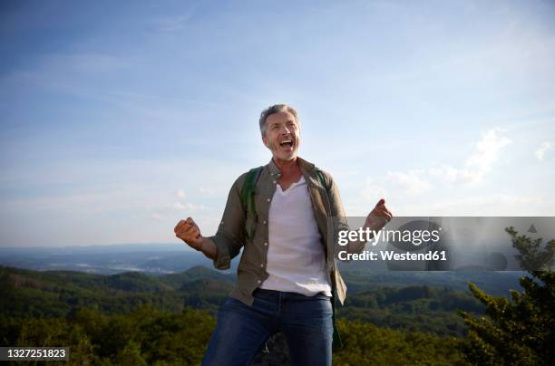 excited man gesturing fist while screaming - chillar fotografías e imágenes de stock