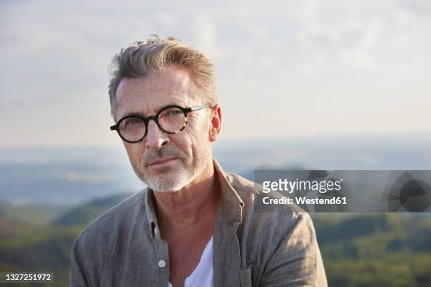 handsome mature man with gray hair and stubble wearing eyeglasses - retrato hombre fotografías e imágenes de stock