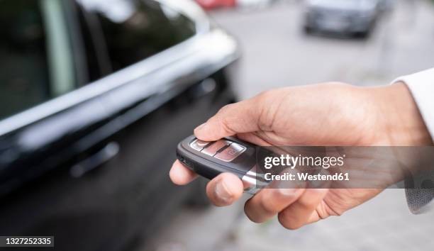 businesswoman unlocking car with remote key - car keys hand stockfoto's en -beelden
