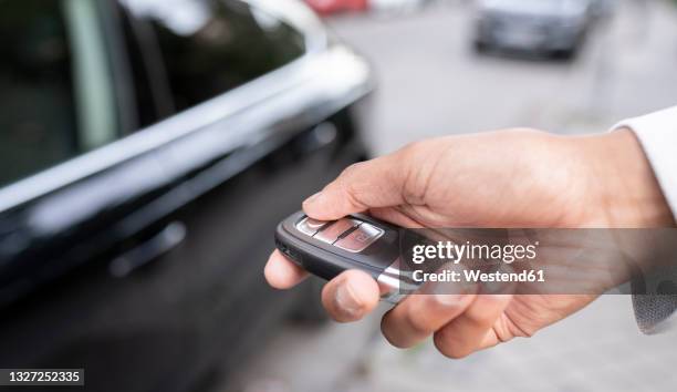 businesswoman unlocking car with remote key - car keys hand stock pictures, royalty-free photos & images