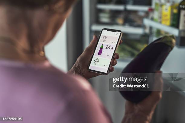 woman counting calories through smart phone app at home - self discipline imagens e fotografias de stock