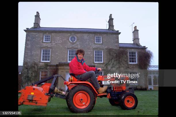 Television presenter Jeremy Clarkson, host of Jeremy Clarkson's Motorworld, driving a miniature tractor around his garden, circa January 1995.