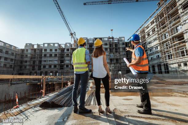 建物とクレーンを示す建設現場の認識できない従業員 - 不動産開発業者 ストックフォトと画像