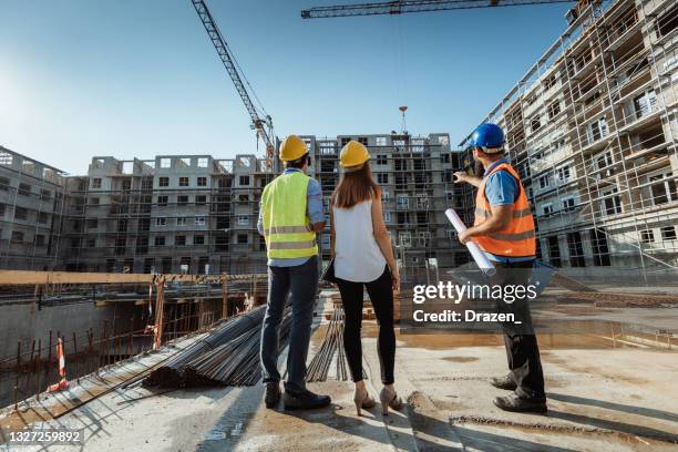 unrecognizable employees on construction site, showing the building and cranes - public housing stock pictures, royalty-free photos & images