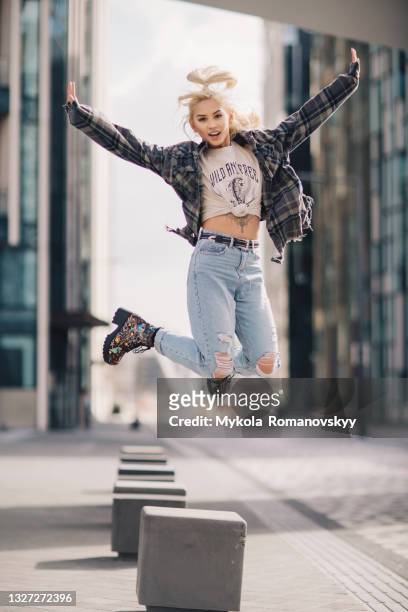 happy blonde woman jumps over the empty city street - shirt mockup stock pictures, royalty-free photos & images