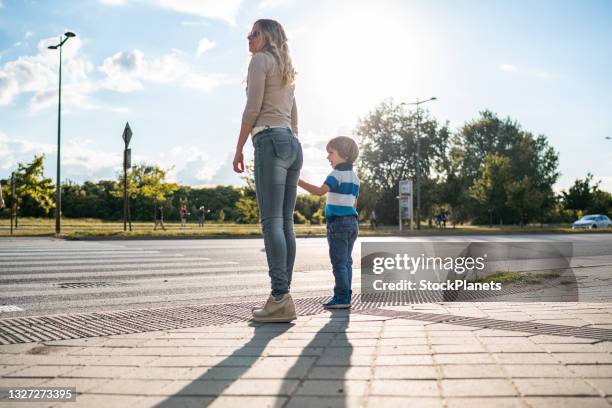 madre e figlio attraversano la strada - attraversare foto e immagini stock