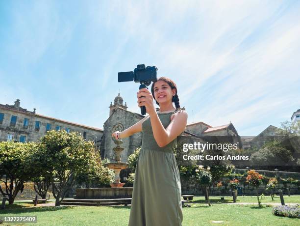 teenage girl recording a video blog outdoors - camera girls stock pictures, royalty-free photos & images