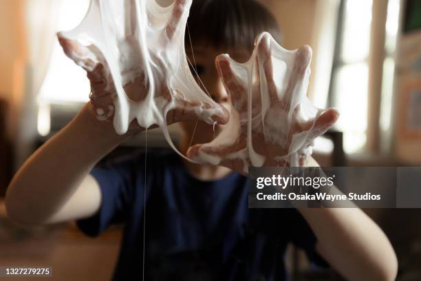 hand covered with some thick white sticky substance, slime or glue - kleverig stockfoto's en -beelden