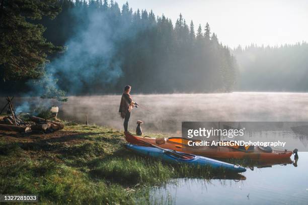 woman fishing during camping in the mountains. - boot camp stockfoto's en -beelden