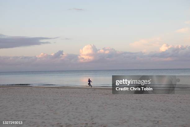 young boy running on the beach by the sea - bright future stock pictures, royalty-free photos & images