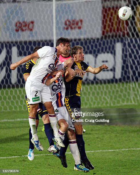 Josh Mitchell of Perth Glory heads the ball under pressure from Patrick Zwaanswijk of Central Coast Mariners during the round four A-League match...