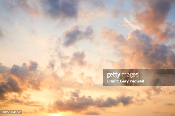 fluffy clouds at sunset - summer sky fotografías e imágenes de stock