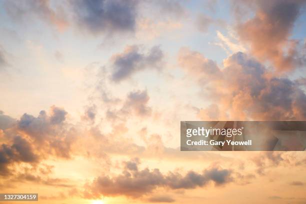 fluffy clouds at sunset - sunset stock pictures, royalty-free photos & images
