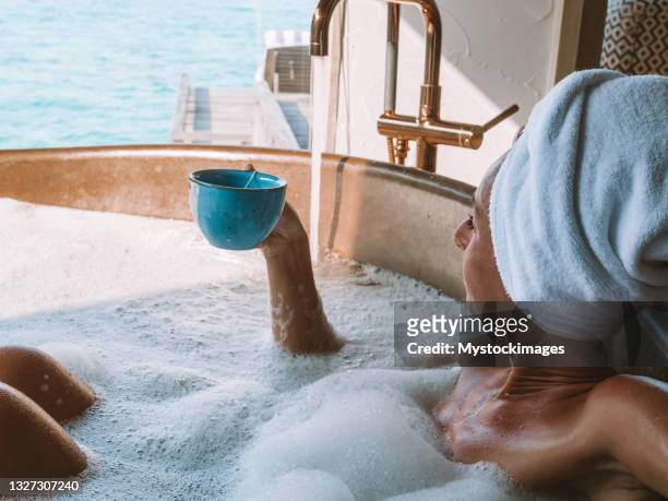 junge frau, die ein bad in luxus-villa über dem meer genießen eine tasse kaffee - bath spa stock-fotos und bilder