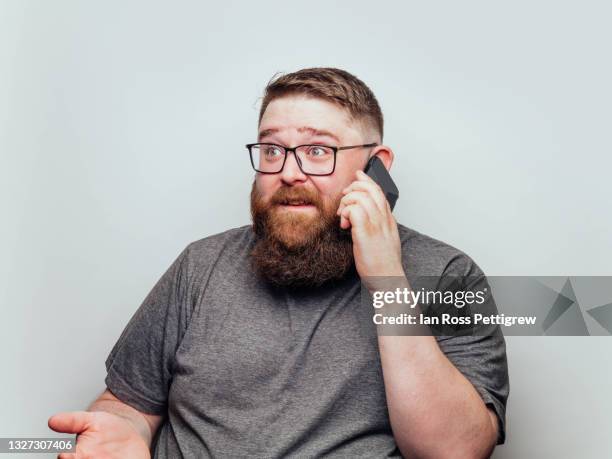 bearded man talking on smartphone - fat man beard stock pictures, royalty-free photos & images