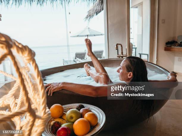 young woman taking a bath in luxury villa over sea - beach glamour stock pictures, royalty-free photos & images
