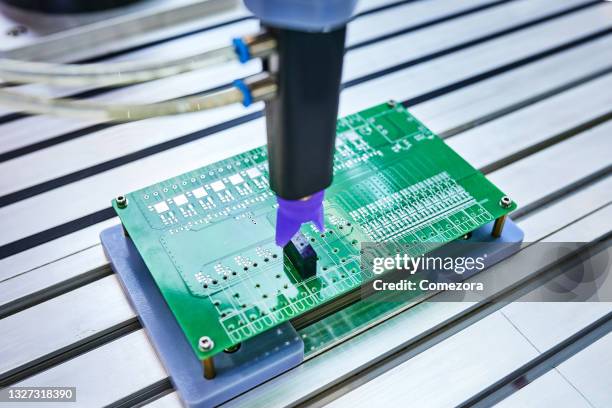 robotic arm installing component at circuit board - industry sensor stock pictures, royalty-free photos & images