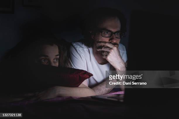couple watching movie on laptop at night - couple watching movie ストックフォトと画像
