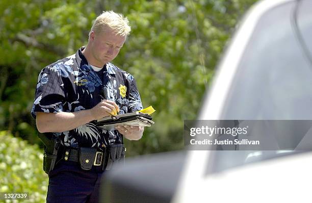 Wearing a Hawaiian shirt uniform, Capitola Police Officer Andrew Dally writes a parking ticket July 16, 2001 in Capitola, CA. The Capitola Police...