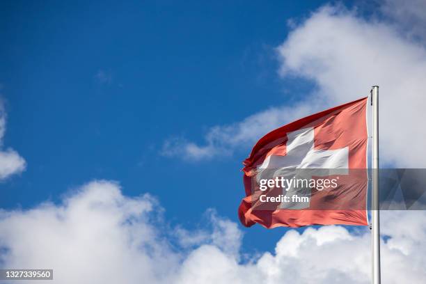swiss flag with sky - schweizer flagge stock-fotos und bilder