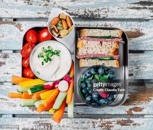 lunch box (sandwich, vegetables, berries and yogurt) on wooden, blue background - jause stock-fotos und bilder