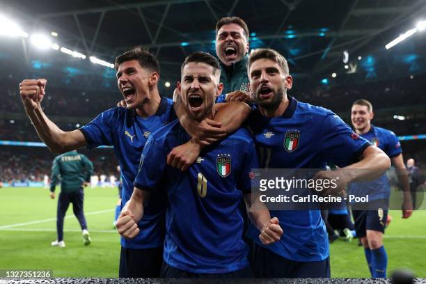 Jorginho of Italy celebrates with Matteo Pessina and Domenico Berardi after scoring their sides winning penalty in the penalty shoot out during the...